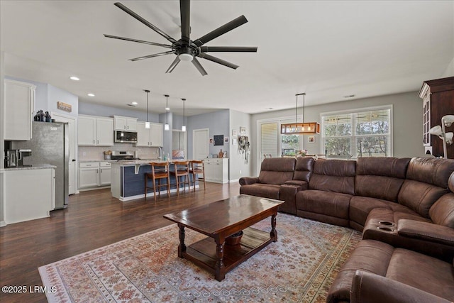 living room with ceiling fan and dark hardwood / wood-style flooring