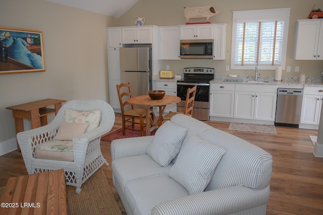 living area with lofted ceiling and light wood-type flooring