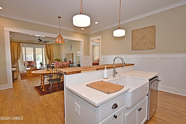 kitchen featuring hanging light fixtures, light wood-style floors, and crown molding