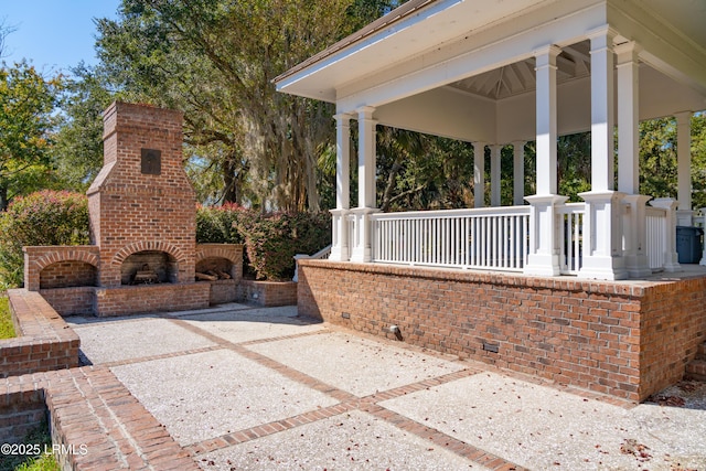 view of patio / terrace featuring an outdoor brick fireplace and a porch