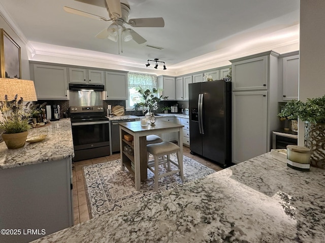 2410 Pine Ct N, Beaufort, SC 29902 - kitchen with appliances with stainless steel finishes, under cabinet range hood, ceiling fan, light stone countertops, and backsplash