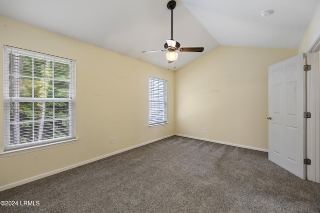 empty room with ceiling fan, a healthy amount of sunlight, lofted ceiling, and carpet