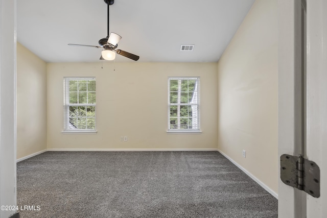 carpeted empty room featuring a wealth of natural light and ceiling fan