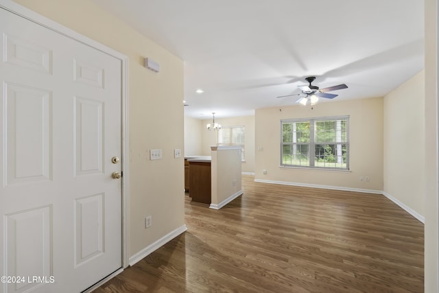 interior space featuring dark hardwood / wood-style floors and ceiling fan with notable chandelier