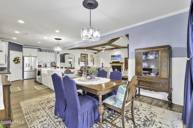 1619 Promenade Ln, Okatie, SC 29909 - dining space with ceiling fan, a stone fireplace, crown molding, a chandelier, and recessed lighting