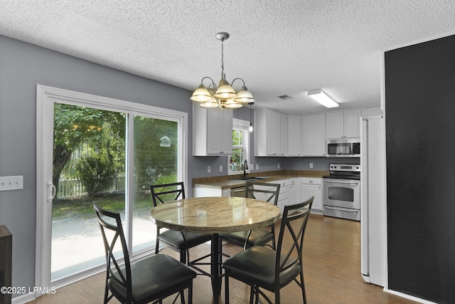 93 Heartstone Cir, Bluffton, SC 29910 - dining space with a chandelier, a textured ceiling, and dark wood-type flooring