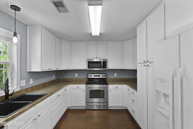 93 Heartstone Cir, Bluffton, SC 29910 - kitchen featuring stainless steel appliances, a sink, a textured ceiling, and white cabinets