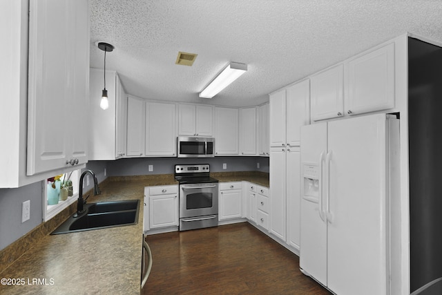 93 Heartstone Cir, Bluffton, SC 29910 - kitchen featuring appliances with stainless steel finishes, a sink, a textured ceiling, white cabinetry, and dark wood finished floors
