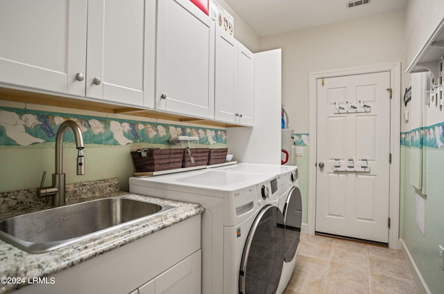 laundry area featuring cabinets, sink, and washing machine and clothes dryer