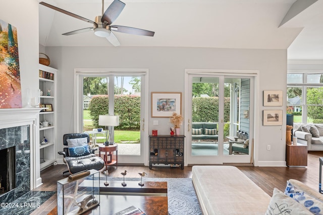 living room with dark hardwood / wood-style flooring, built in features, and a fireplace