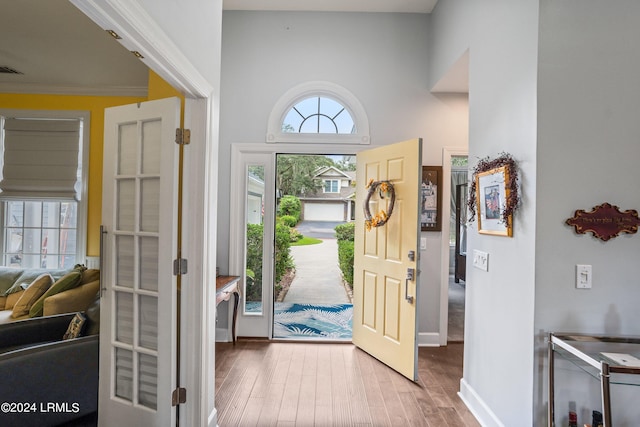 entrance foyer with crown molding and wood-type flooring