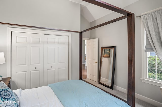 bedroom featuring lofted ceiling, a closet, and carpet