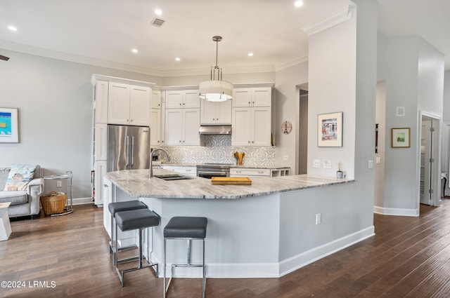 kitchen featuring pendant lighting, sink, white cabinets, light stone counters, and stainless steel appliances