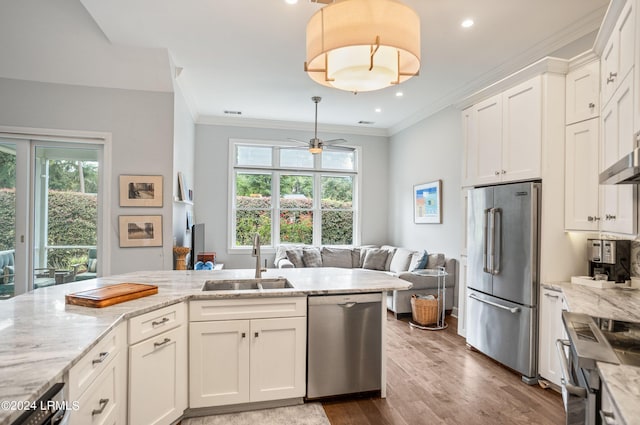 kitchen with light stone counters, sink, stainless steel appliances, and white cabinets