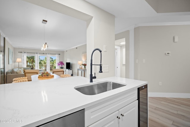 21 S Forest Beach Dr Unit 235, Hilton Head Island, SC 29928 - kitchen featuring hanging light fixtures, light wood-style flooring, a sink, open floor plan, and white cabinets