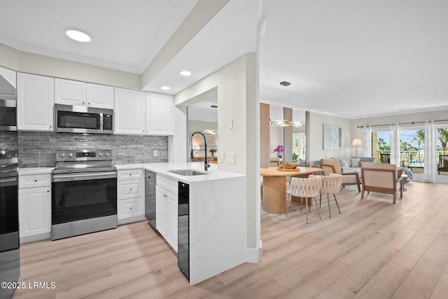 21 S Forest Beach Dr Unit 235, Hilton Head Island, SC 29928 - kitchen featuring a sink, stainless steel appliances, tasteful backsplash, crown molding, and open floor plan