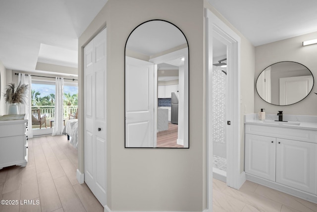 21 S Forest Beach Dr Unit 235, Hilton Head Island, SC 29928 - hallway featuring baseboards, a raised ceiling, and a sink