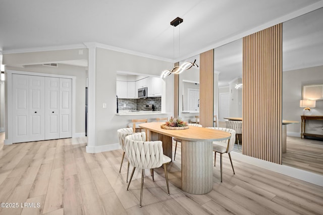 21 S Forest Beach Dr Unit 235, Hilton Head Island, SC 29928 - dining space featuring light wood finished floors, crown molding, baseboards, and visible vents