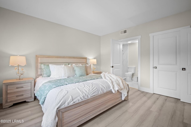 21 S Forest Beach Dr Unit 235, Hilton Head Island, SC 29928 - bedroom with ensuite bathroom, baseboards, visible vents, and wood finished floors