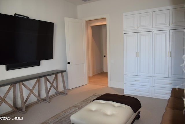 bedroom with light carpet and a closet