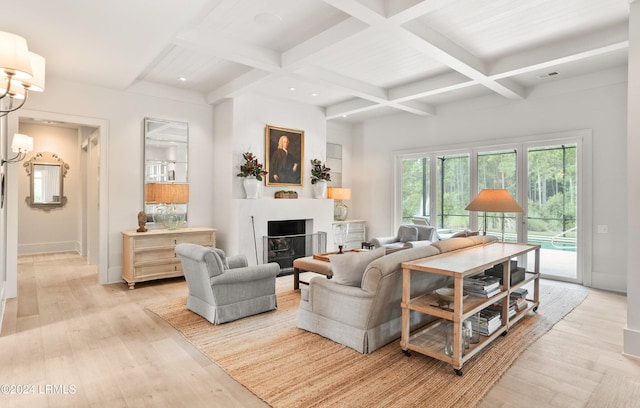 living room with a notable chandelier, coffered ceiling, beam ceiling, and light hardwood / wood-style flooring