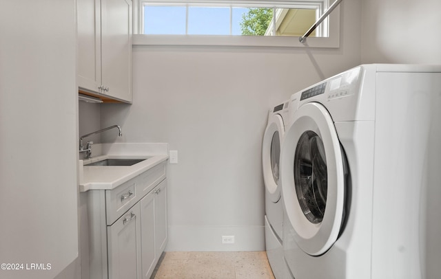 laundry area featuring sink, washing machine and dryer, and cabinets