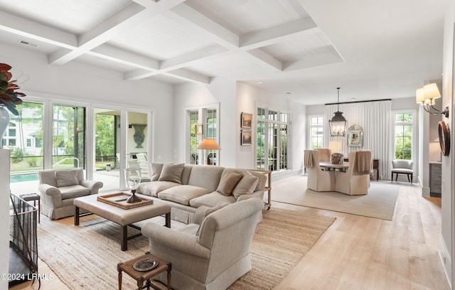 living room featuring beamed ceiling, coffered ceiling, a notable chandelier, and light wood-type flooring