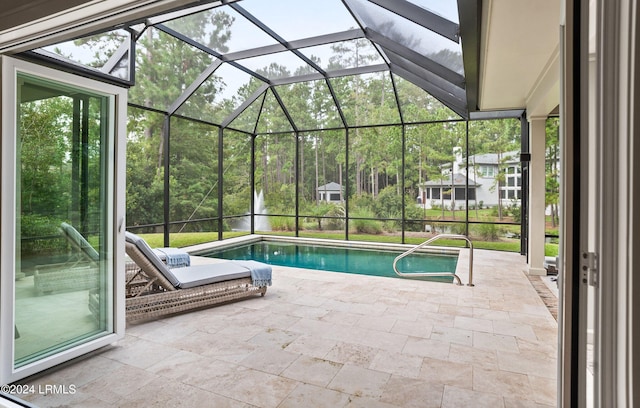 view of pool featuring glass enclosure and a patio area