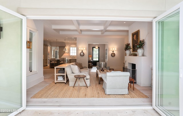 living room featuring coffered ceiling, beam ceiling, and light hardwood / wood-style floors