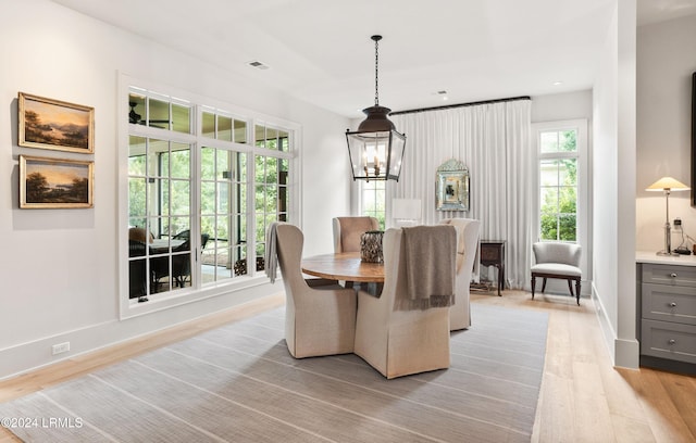 dining area with an inviting chandelier and light hardwood / wood-style floors