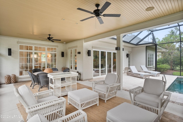 view of patio with ceiling fan, an outdoor hangout area, and glass enclosure