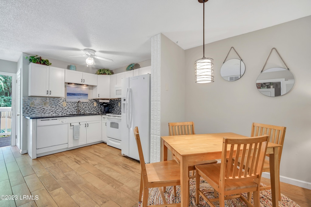 kitchen featuring white cabinetry, white appliances, and decorative light fixtures