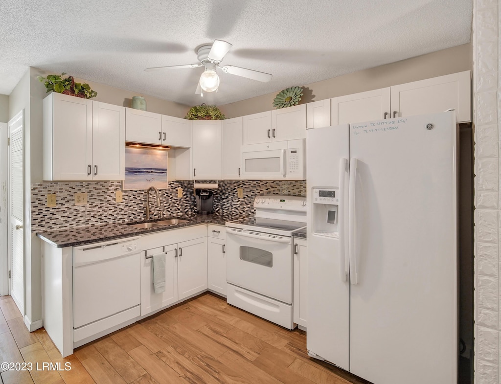 kitchen with sink, white appliances, white cabinetry, tasteful backsplash, and light hardwood / wood-style floors