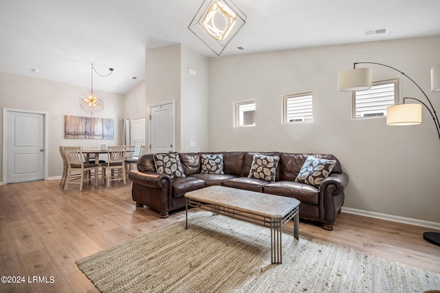 living room featuring vaulted ceiling and light wood-type flooring