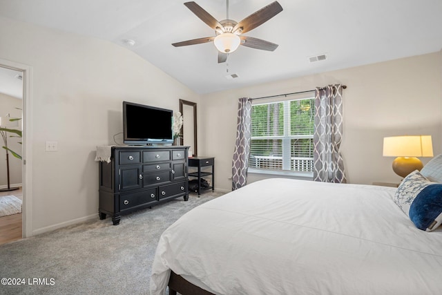 bedroom featuring vaulted ceiling, light colored carpet, and ceiling fan