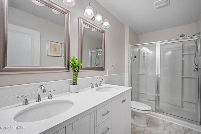 bathroom featuring an enclosed shower, vanity, and toilet