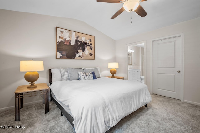 carpeted bedroom with ceiling fan, vaulted ceiling, and ensuite bath