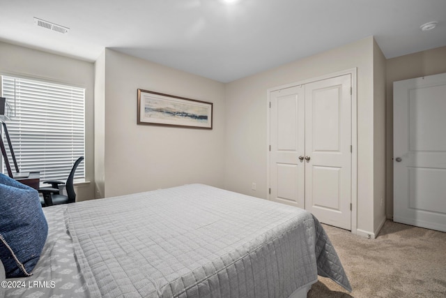 bedroom with a closet and light carpet