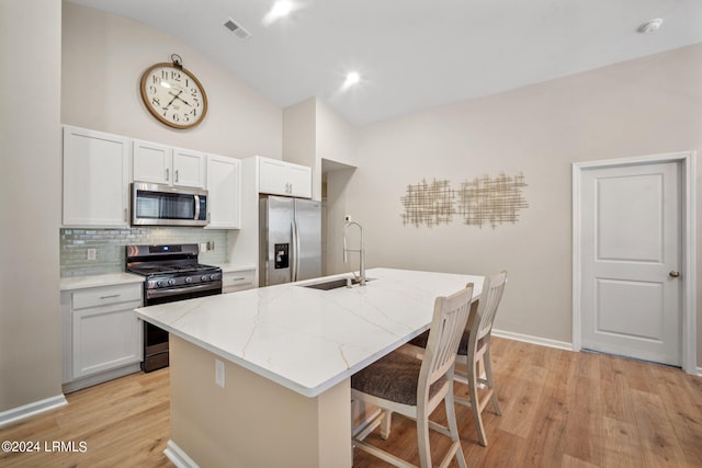 kitchen featuring white cabinets, appliances with stainless steel finishes, sink, and a kitchen island with sink