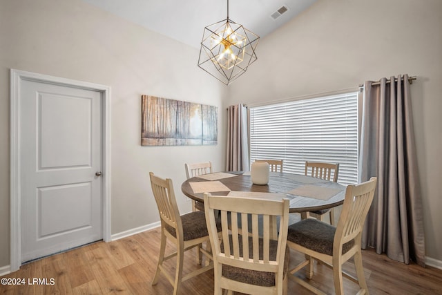 dining area featuring vaulted ceiling, a chandelier, and light hardwood / wood-style flooring