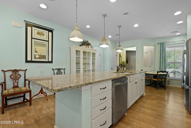 127 Kings Creek Dr, Bluffton, SC 29909 - kitchen with stainless steel appliances, a sink, white cabinetry, a kitchen island with sink, and light wood-style floors