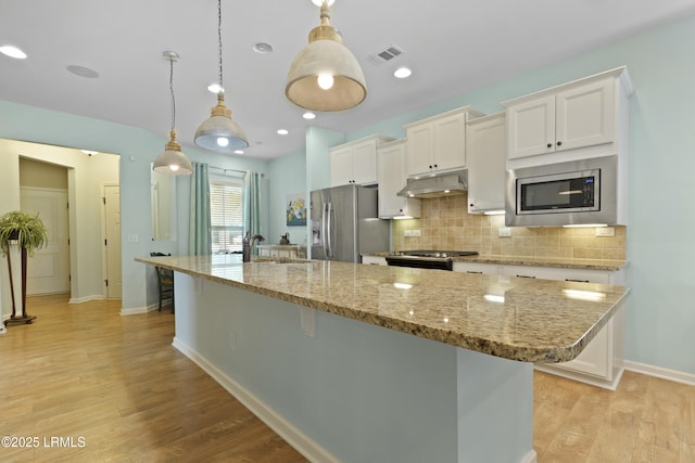 127 Kings Creek Dr, Bluffton, SC 29909 - kitchen featuring stainless steel appliances, a center island, white cabinets, a kitchen bar, and backsplash