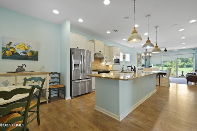 127 Kings Creek Dr, Bluffton, SC 29909 - kitchen with stainless steel appliances, light stone counters, under cabinet range hood, a breakfast bar area, and a sink