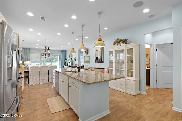 127 Kings Creek Dr, Bluffton, SC 29909 - kitchen featuring white cabinetry, a sink, appliances with stainless steel finishes, light wood-type flooring, and a center island with sink
