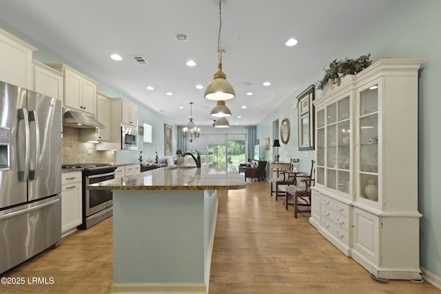 127 Kings Creek Dr, Bluffton, SC 29909 - kitchen featuring appliances with stainless steel finishes, under cabinet range hood, a sink, light stone counters, and an island with sink
