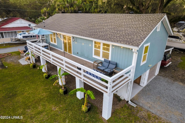 rear view of property featuring a wooden deck, an outdoor living space, and a lawn