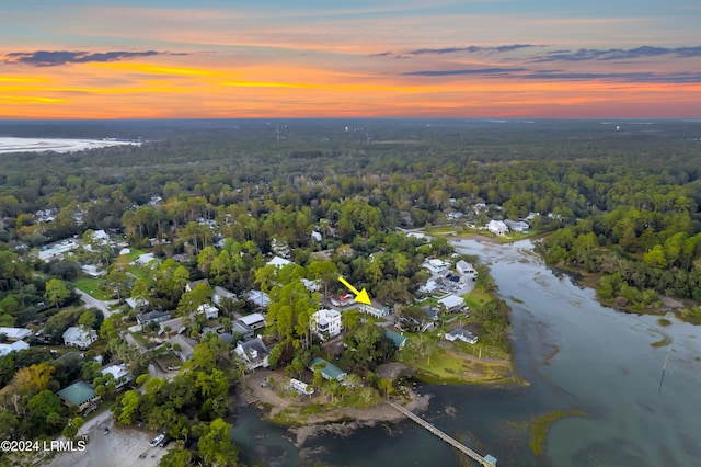 aerial view at dusk featuring a water view