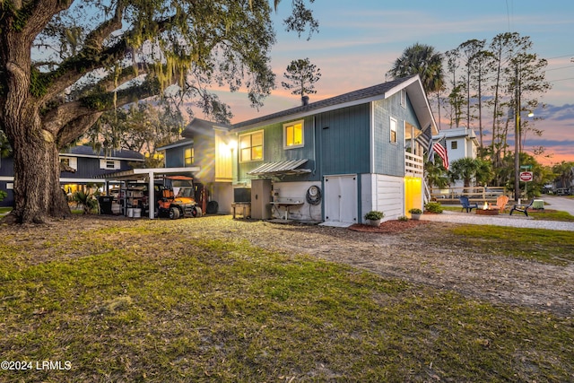 back house at dusk featuring a yard