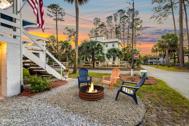 yard at dusk featuring an outdoor fire pit