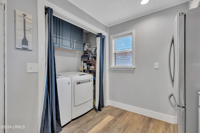 laundry room featuring cabinets, separate washer and dryer, and light hardwood / wood-style flooring